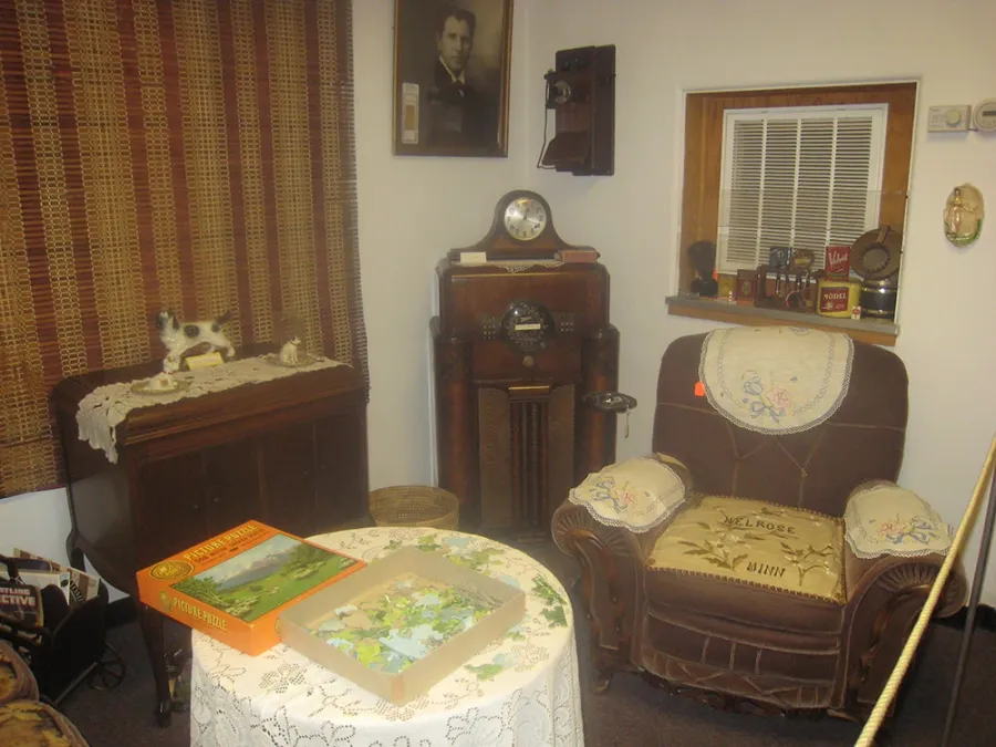 Period parlor exhibit with a radio and upholstered chair